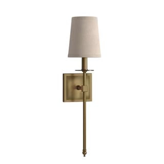 A wall sconce with a white lampshade and long brass base