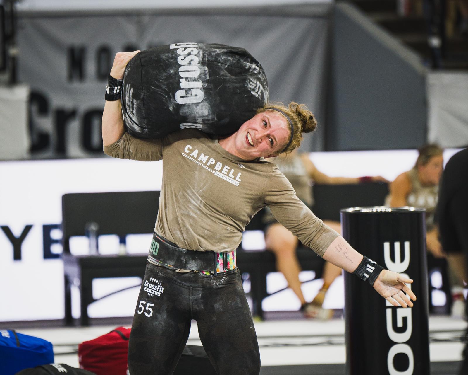 Lucy Campbell with sandbag on her shoulder during CrossFit competition