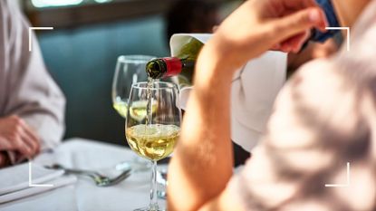 Woman pouring low alcohol wines into a glass at dining table with white tablecloth