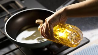 Oil being tipped into a pan for cooking