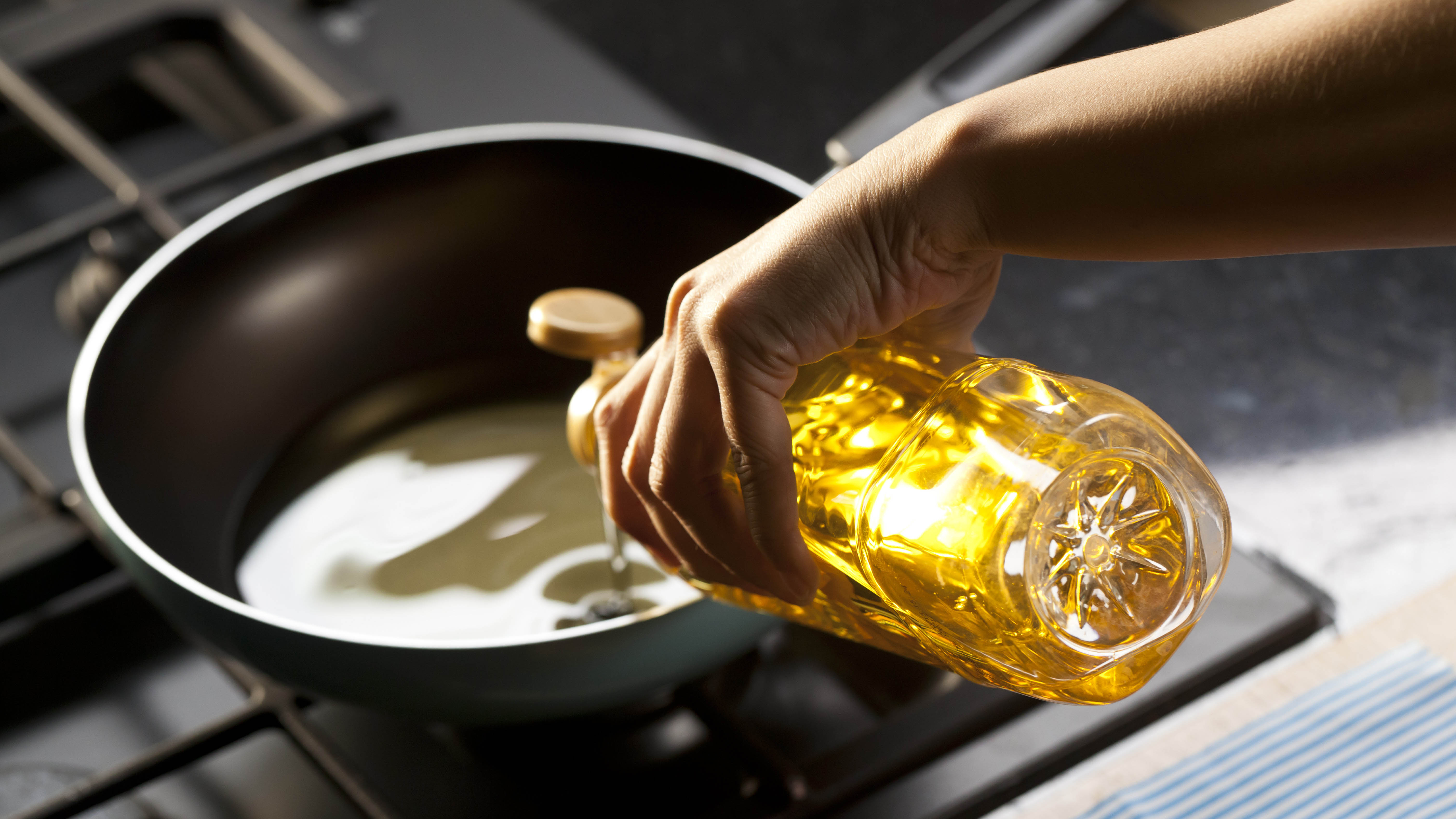 Масло выливается в сковороду для приготовления пищи
