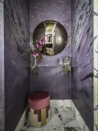 A grand purple bathroom featuring marble and gold