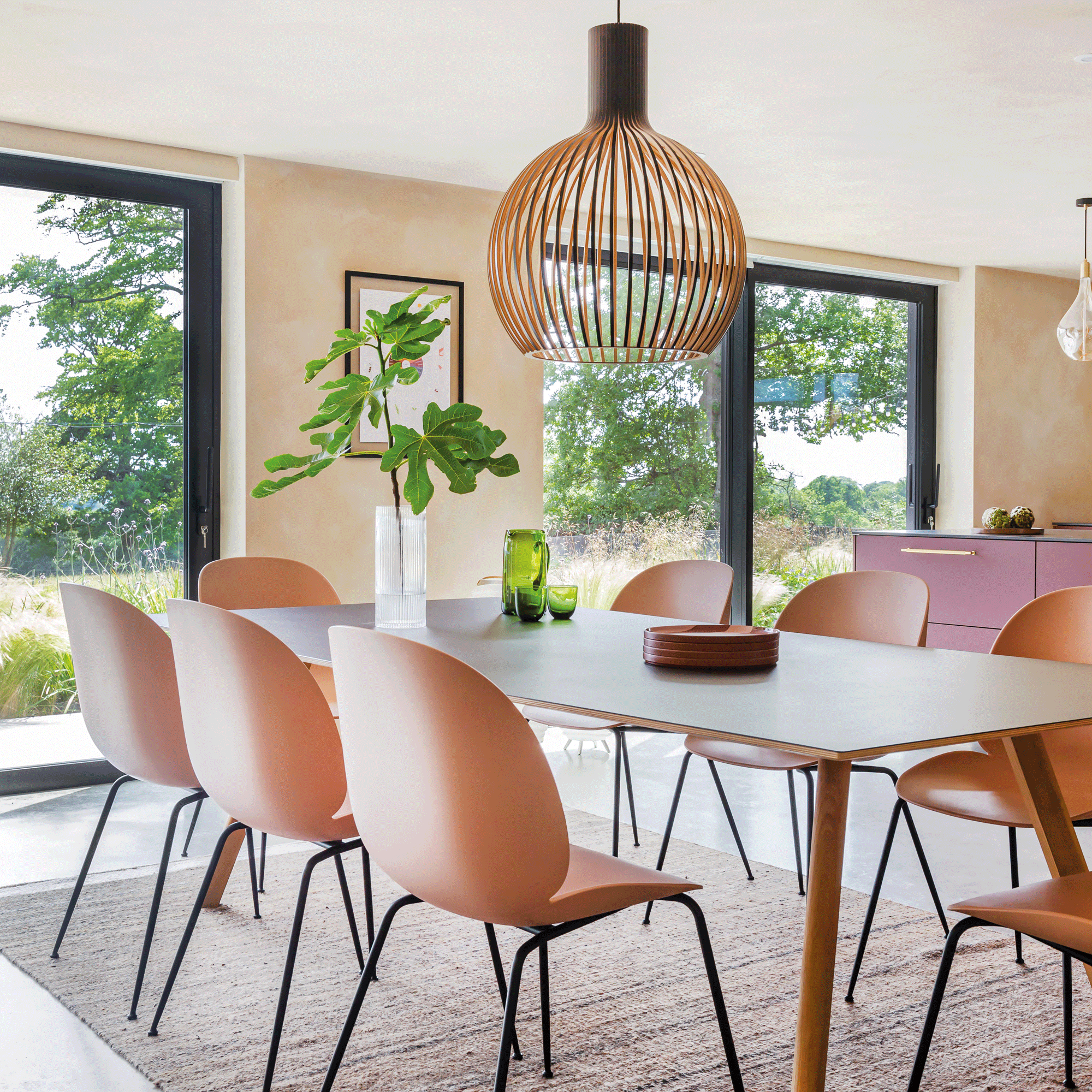 open plan kitchen dining area with a dining table and pink dining chairs