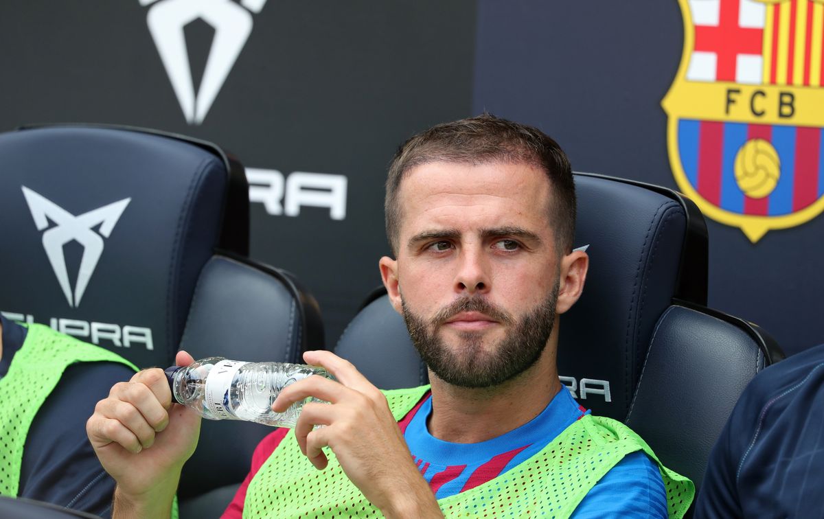 Barcelona midfielder Miralem Pjanic sitting on the bench, holding a bottle of water