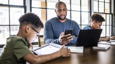 Dad and sons using devices