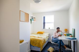 A student sits in her bedroom in student accommodation