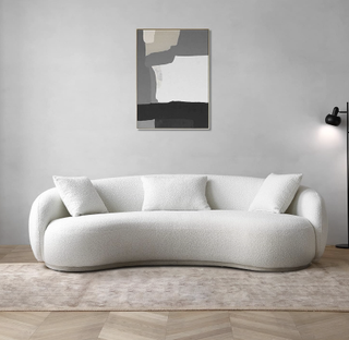 curved white boucle sofa in a grey living room