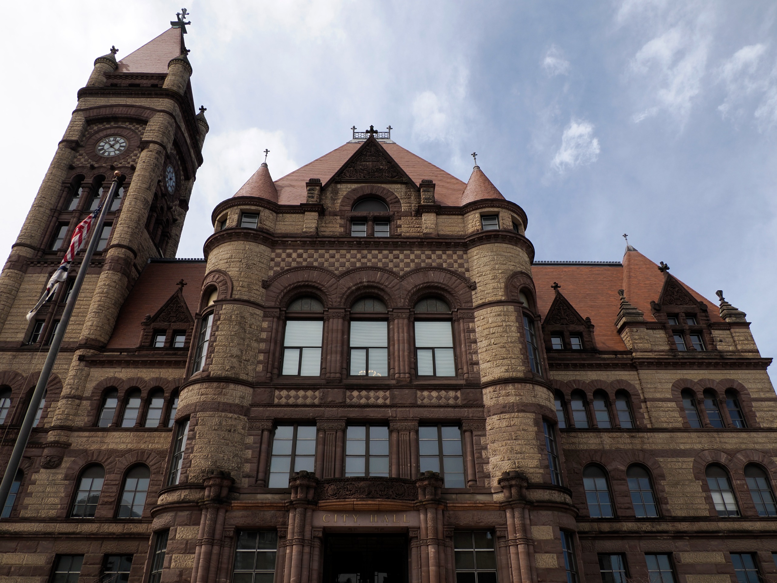 Exterior of the gothic Cincinnati, Ohio city hall building against a blue sky with white clouds