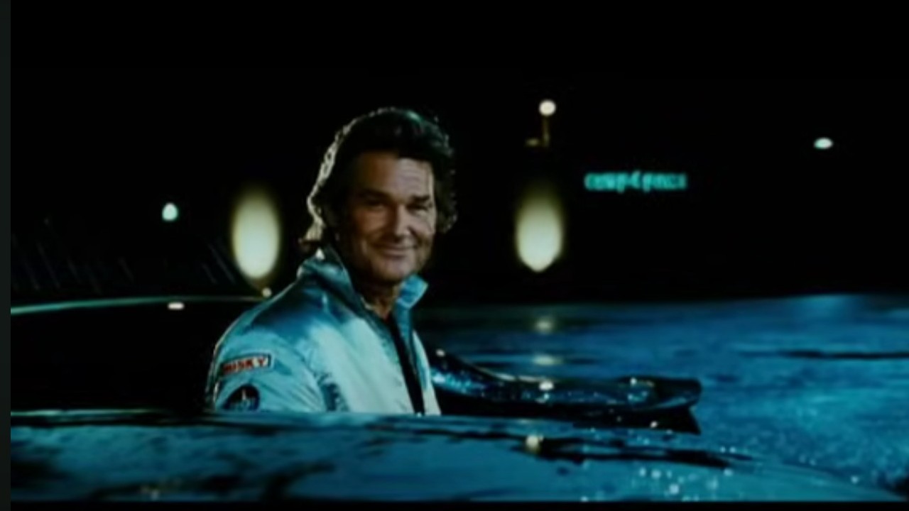 Kurt Russell smiling over his car in Death Proof