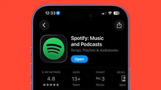 A phone on a red background showing Spotify in the Apple App Store