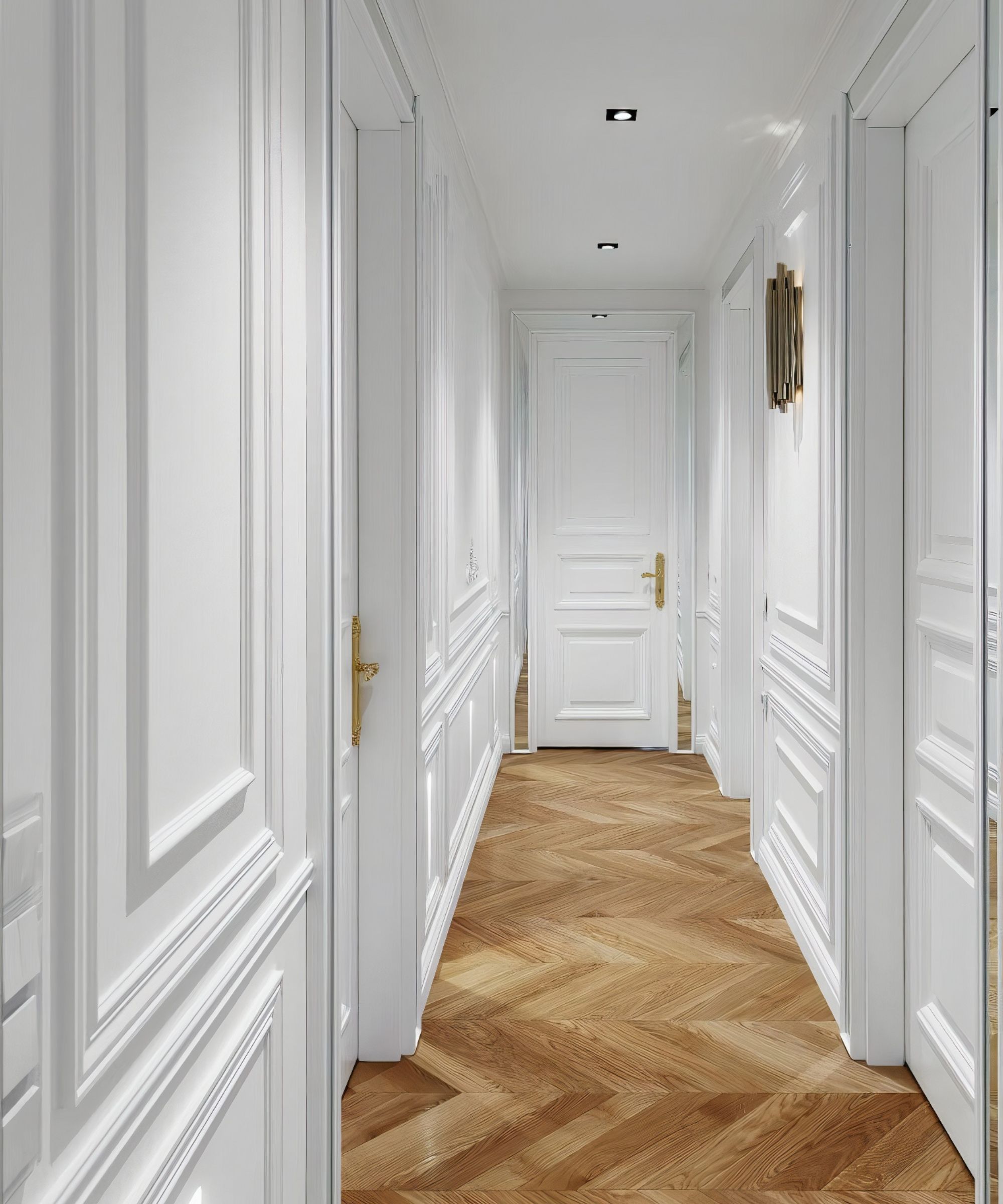 A bright hallway with white panelled walls and doors, contrasted by a warm herringbone-patterned wooden floor. Small recessed ceiling lights and a gold wall sconce provide illumination.