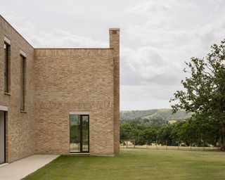 Yellowish-brown handmade buff bricks give warmth to the house, helping to ground it in the landscape, while its location, on rising ground, offers expansive views across the South Downs