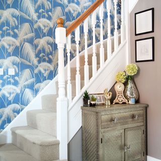 blue wallpapered hallway with stairs