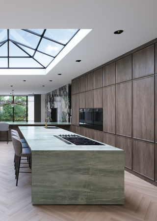 A bright kitchen with wooden storage cabinets and a green marble island