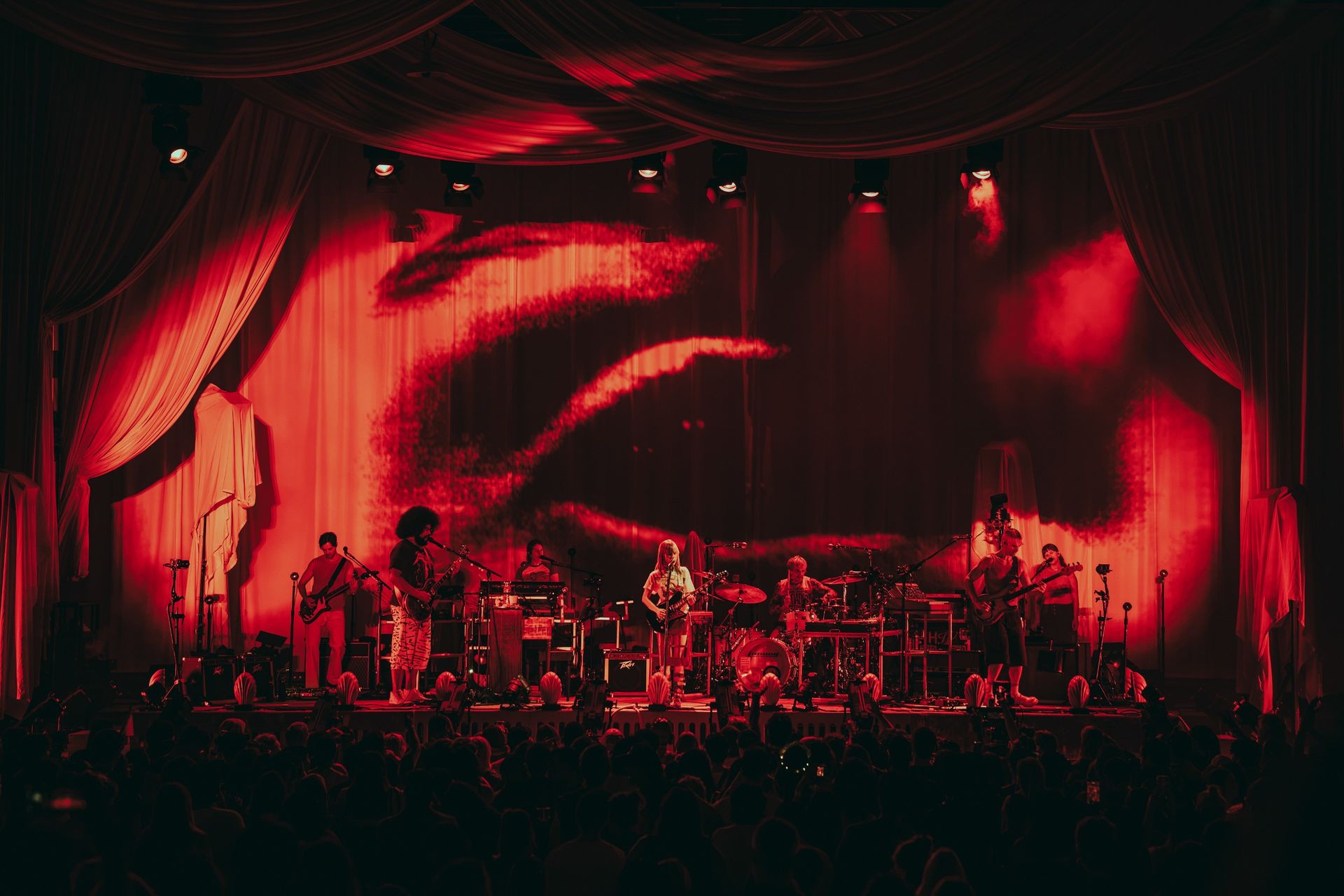 band on stage in pink lighting