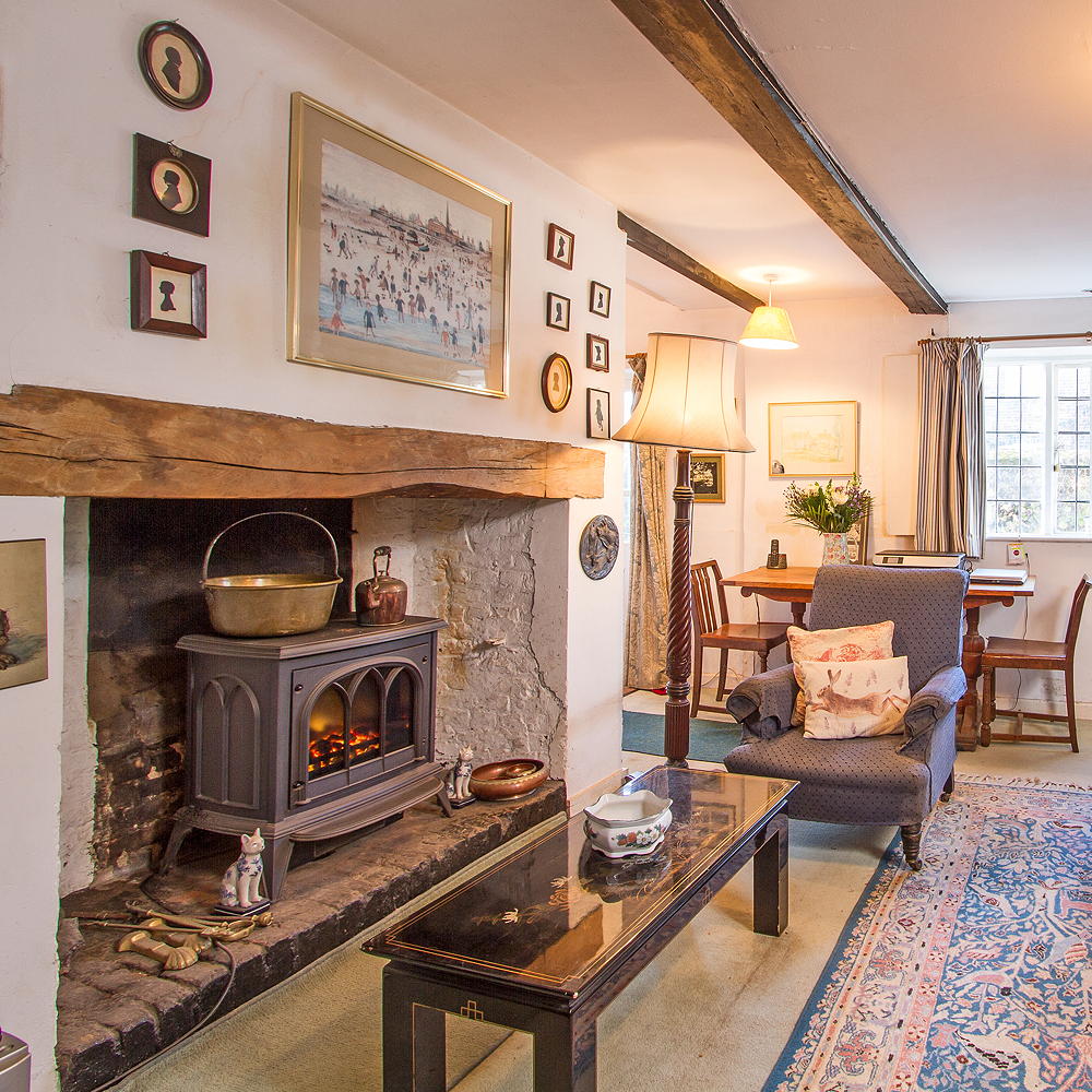 living area with white wall and arm chair and fire place
