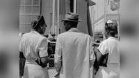 Three African-American people pictured from behind. They are dressed smartly. 