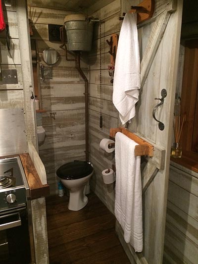 A flushing loo and instant hot water shower is hidden behind a door
