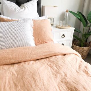 Light and airy bedroom space with apricot sheets and white pillows