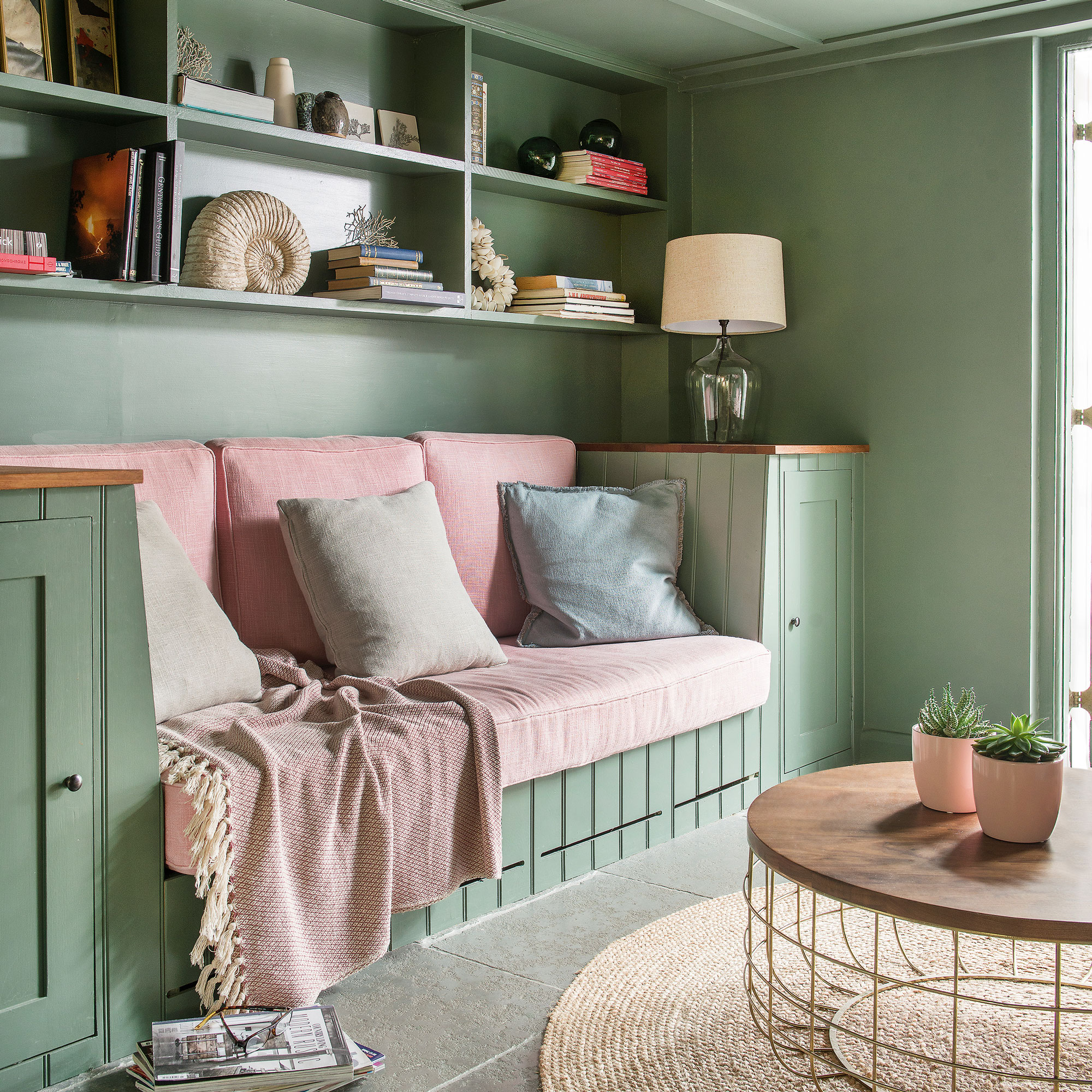 Green living room with table lamp and pink cushions