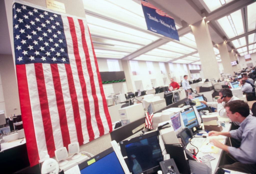Employees with an American flag in the Merrill Lynch office in their headquarters on the World Financial Center Equity Trading Floor following the September 11th terrorist attacks.
