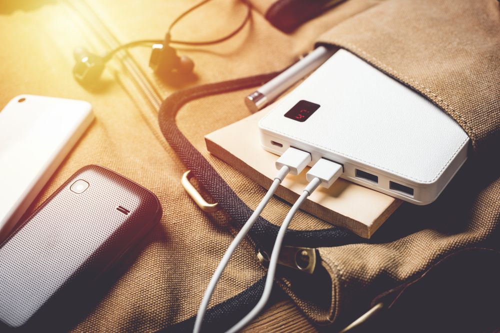 A smartphone charging in a bag via a white power bank