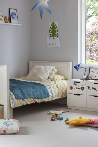 how to design a kid's room A white children's bedroom with blue accents and soft flooring