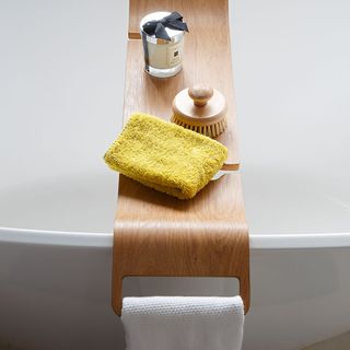 bathtub with bath rack and towel
