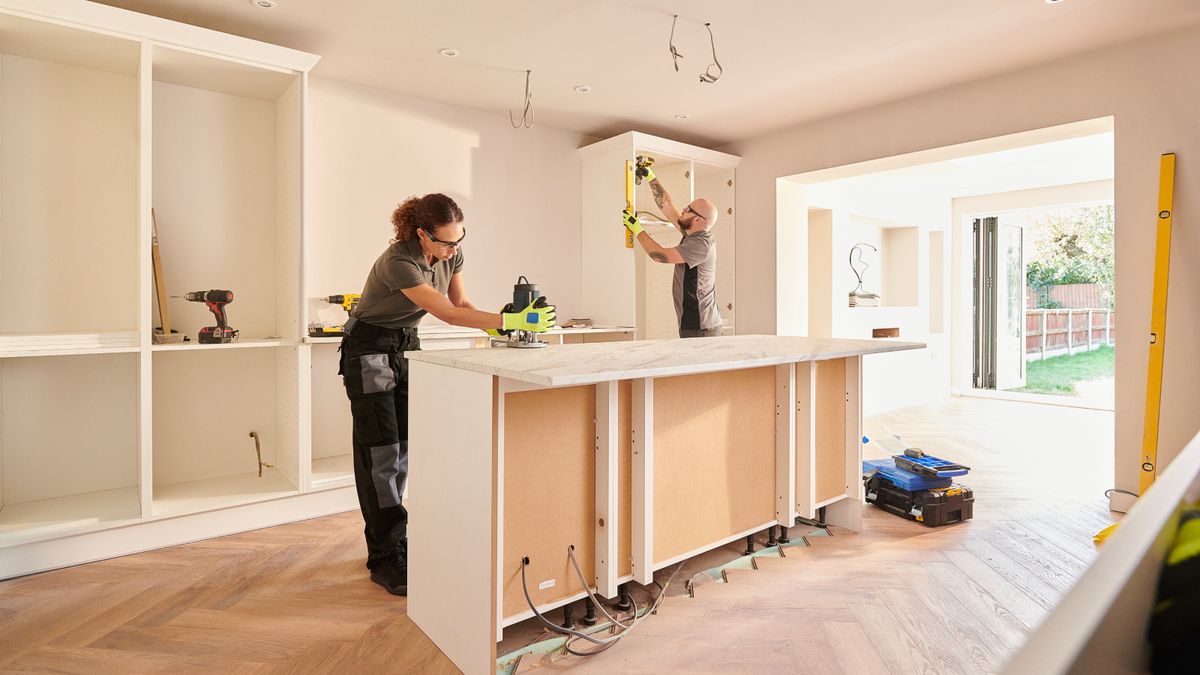 male and female wearing safety goggles fitting a kitchen