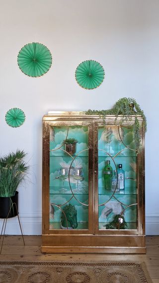 A turquoise display cabinet decorated with gilded gold leaf