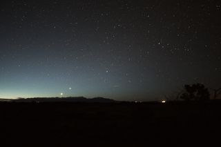 a photograph of the night sky with several bright orbs shining among the background stars