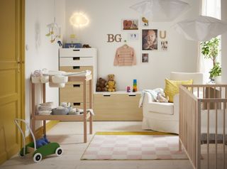 a nursery room with changing table, cot and seat