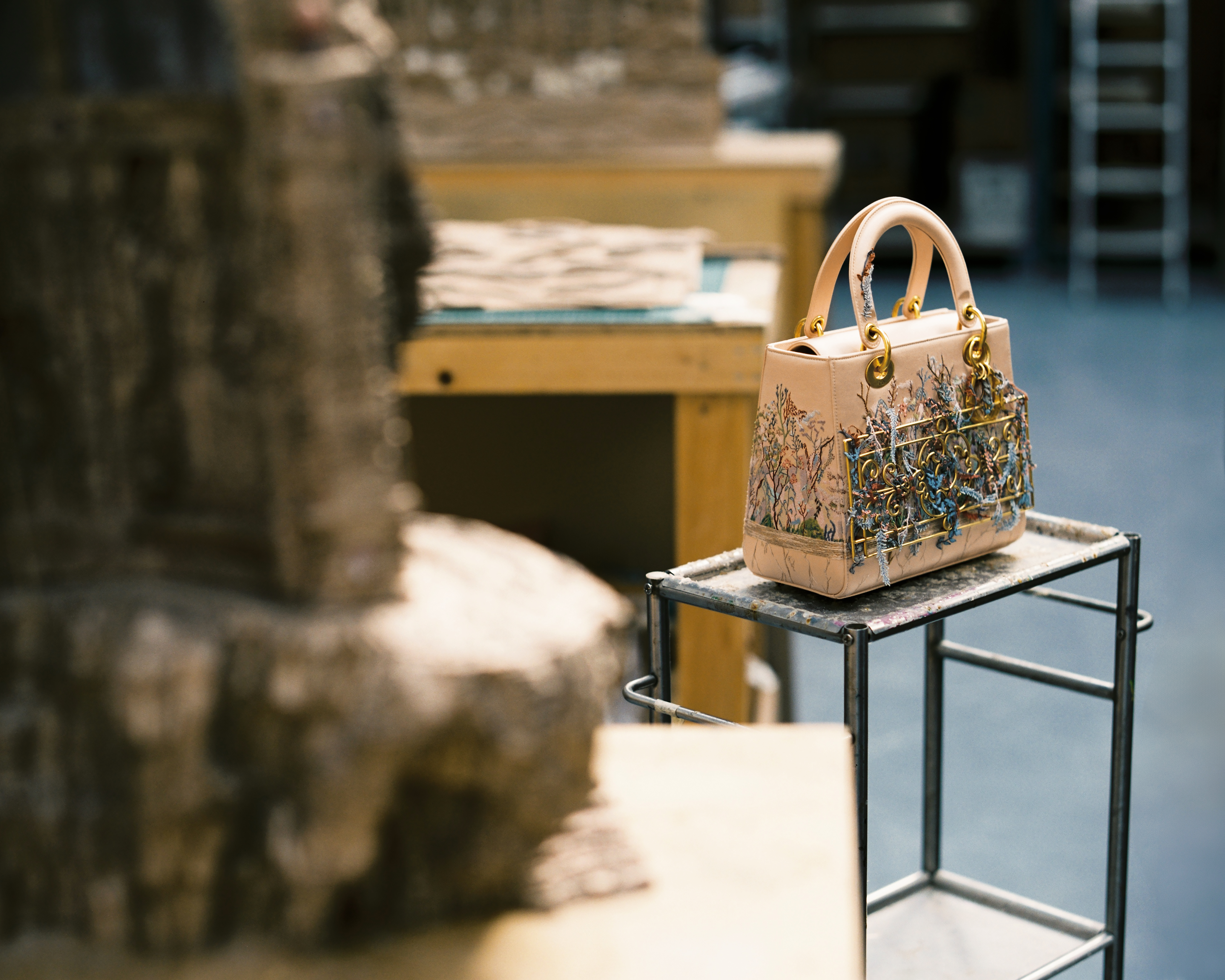 a lady dior art bag on a stand