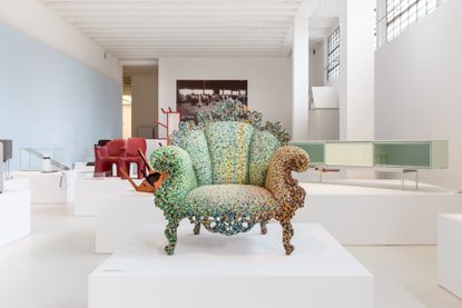 Alessandro Mendini’s Poltrona di Proust. A colourful armchair with a shell shaped back on a white square platform.