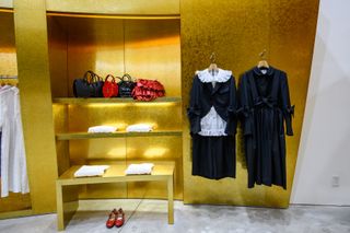 Inside Comme des Garçons store with gold background