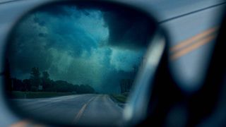 Reflection of a tornado in a car's side view mirror in Netflix's "The Twister: Caught in the Storm"