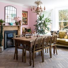 dinning room with pink wall wooden dinning table with chairs and plant
