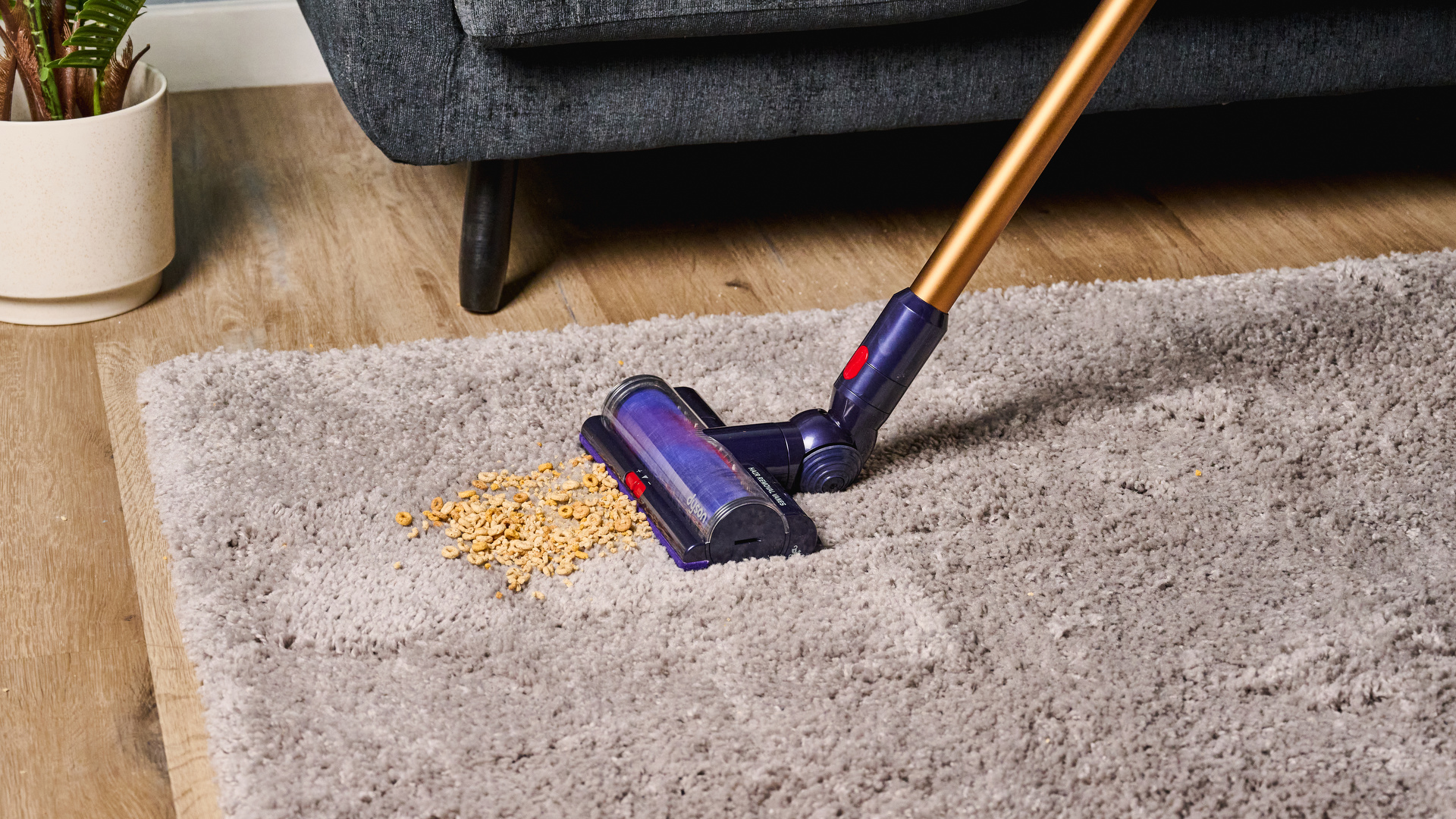 the dyson gen5detect cordless stick vacuum in prussian blue and copper, showing its cleaning head and attachment tools