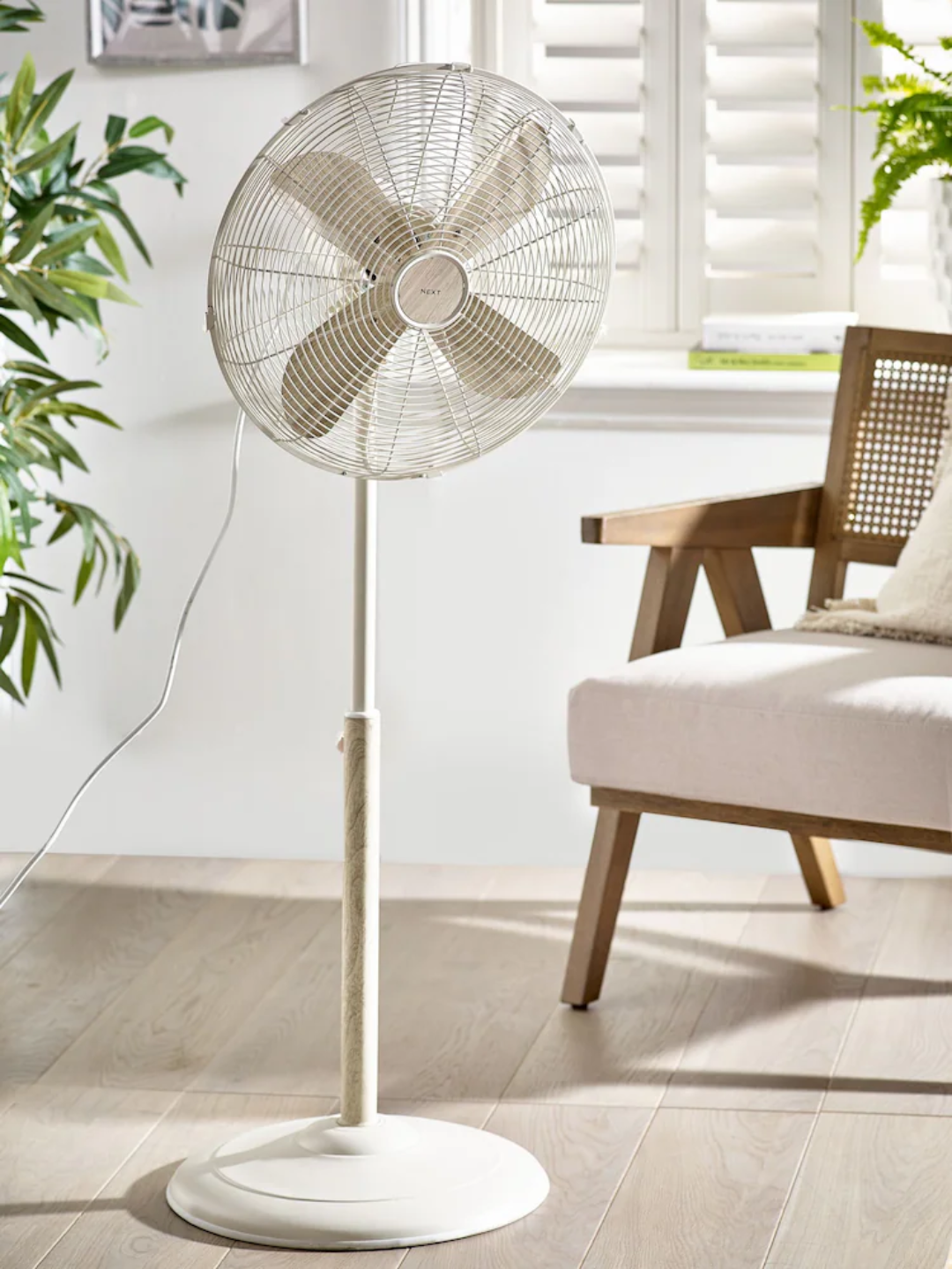 A cream pedestal fan from Next in a living room