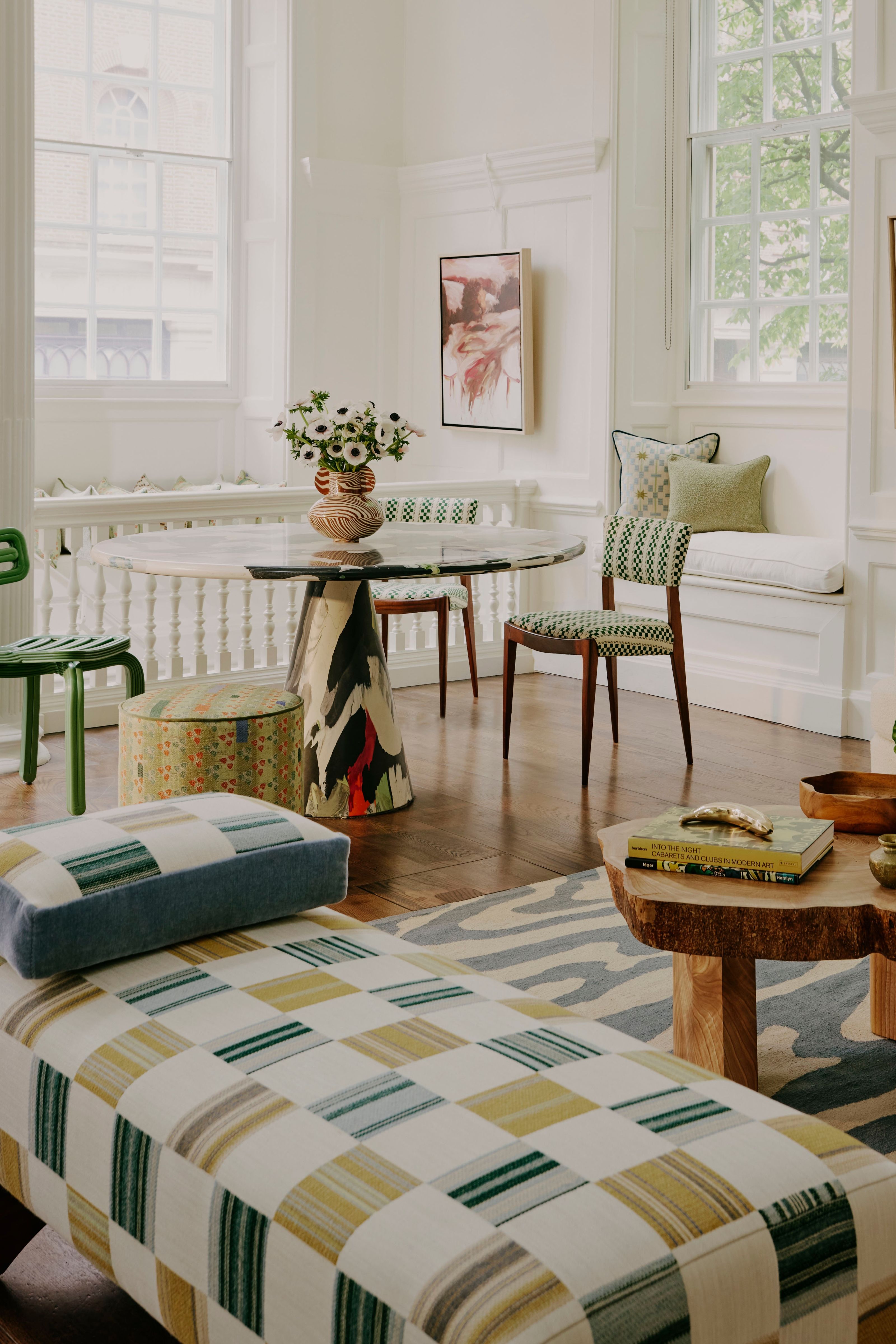 a white room with a checkerboard ottoman and a recycled plastic table