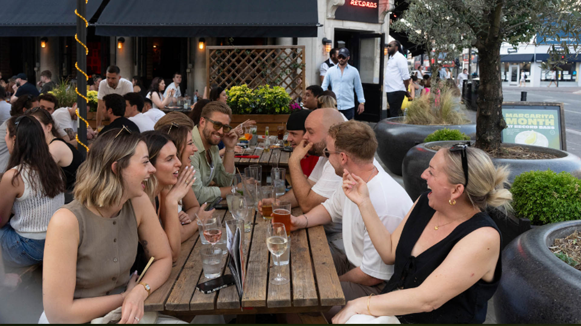 A photo of people drinking on a bench. 