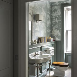 bathroom with wash basin and wallpaper on wall