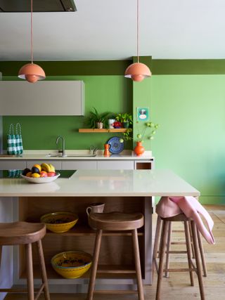 A corridor and a kitchen both painted in hyper green