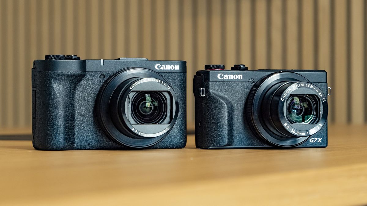 Canon PowerShot V1 compact vlogging camera on a wooden desk alongside the PowerShot G7X Mark III