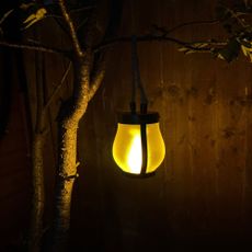 Adiwo Solar Flame Hemp Rope Lantern in garden after dark