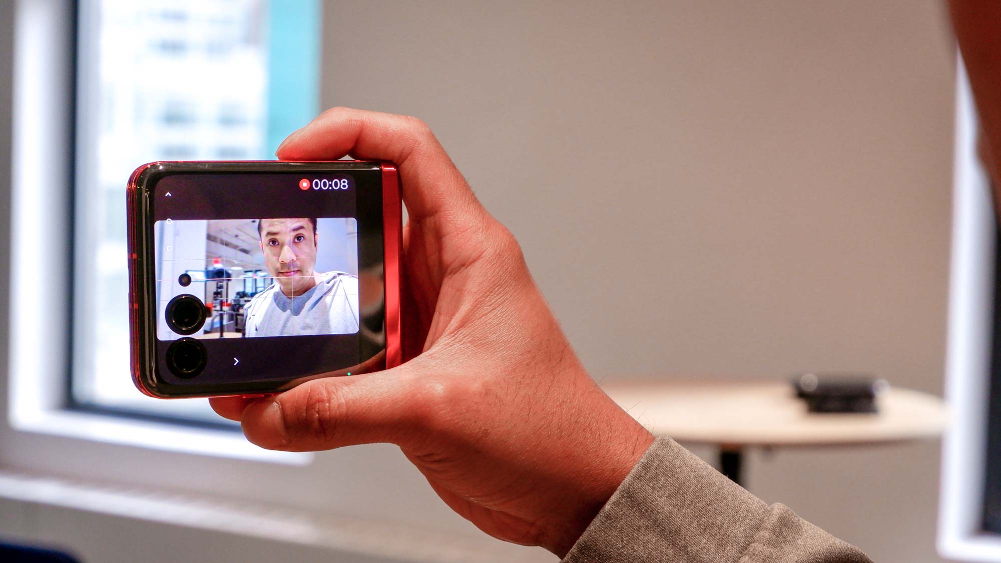 Man taking selfie using rear camera and external display on the Motorola Razr+.