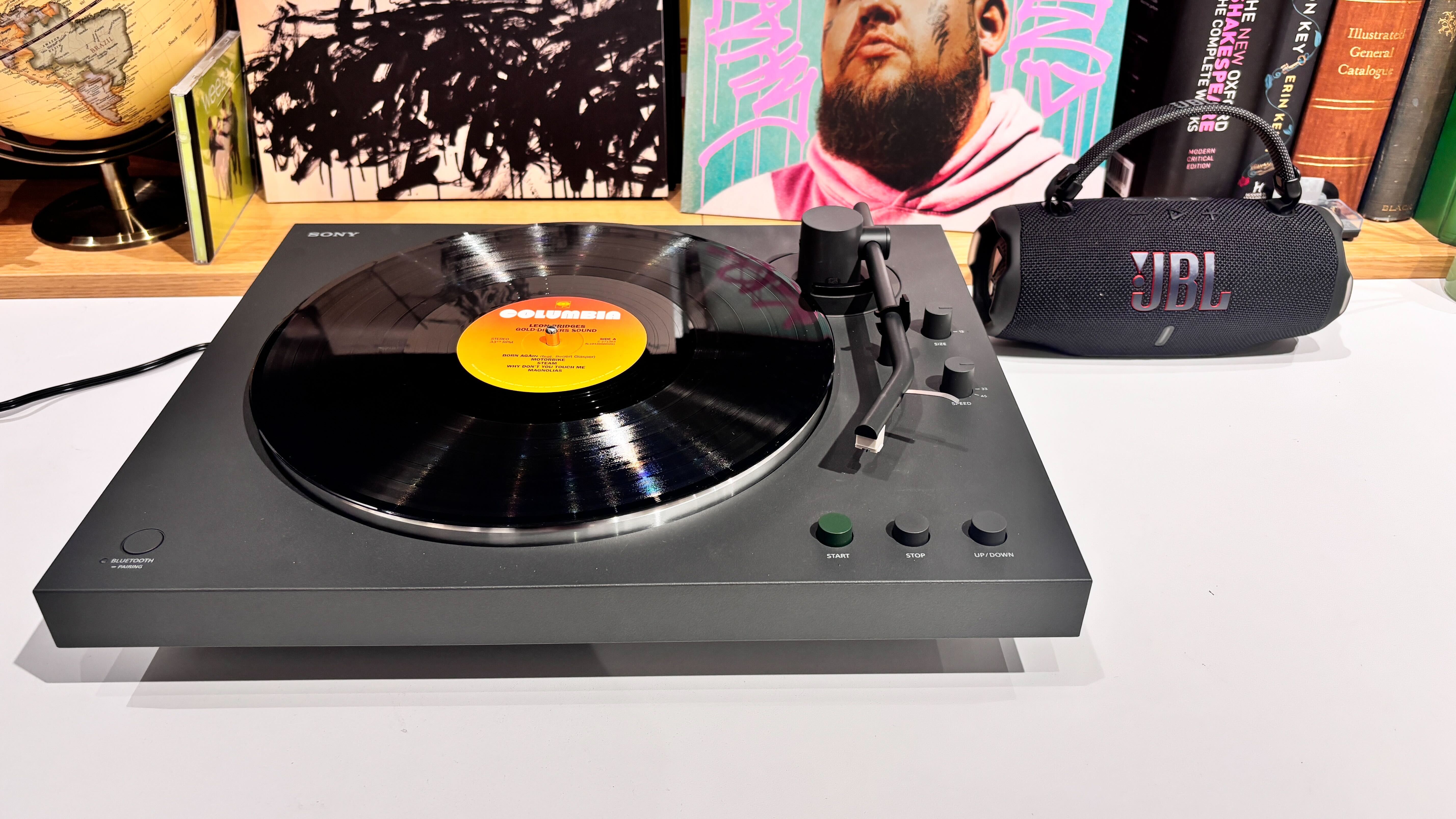 Sony PS-LX3BT turntable on white desk with JBL Charge 6 Bluetooth speaker