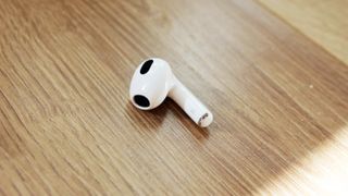 Et closeup af en airpods 3 earbud