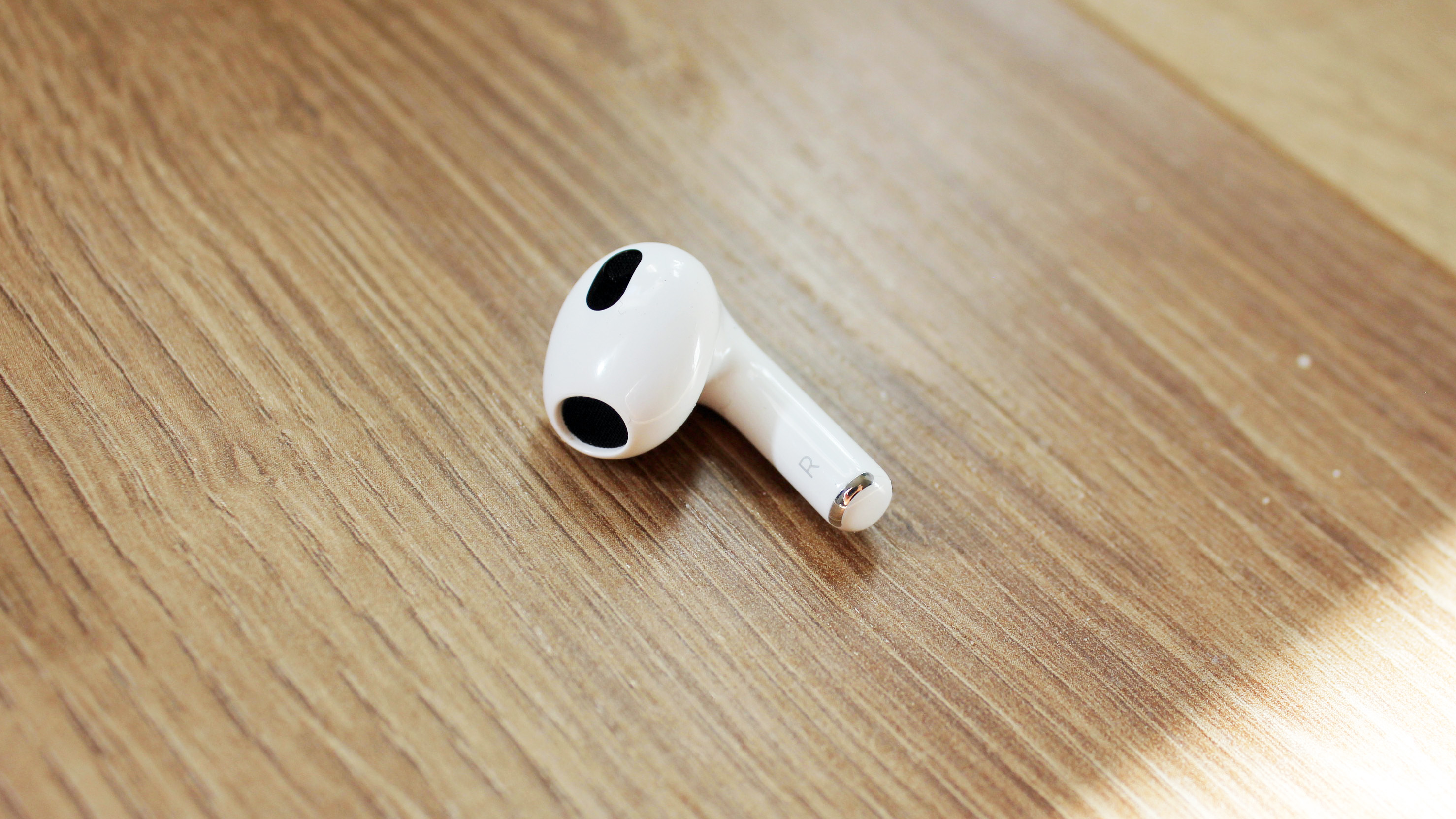 a closeup of one airpods 3 earbud