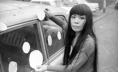 Artist Yayoi Kusama next to her Dot Car, 1965